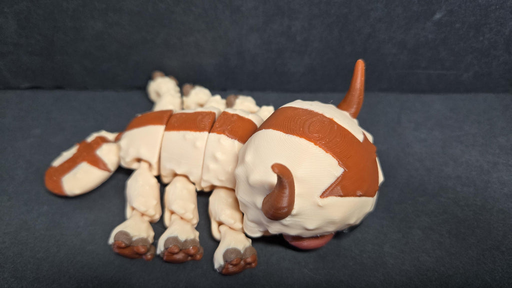 Side profile view of the flexible Appa figure lying down to showcase body articulation