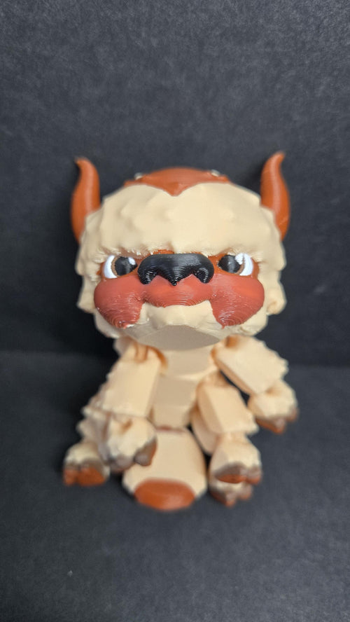 Straight front view of the articulated Appa flexi figure sitting on a flat surface
