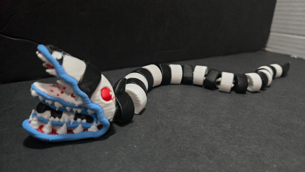 Articulated Beetlejuice sandworm figure stretched out in an S-curve pose