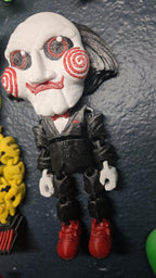 Left side profile view of the flexible Jigsaw puppet monster toy showing the head silhouette, hair texture, and arm articulation joints