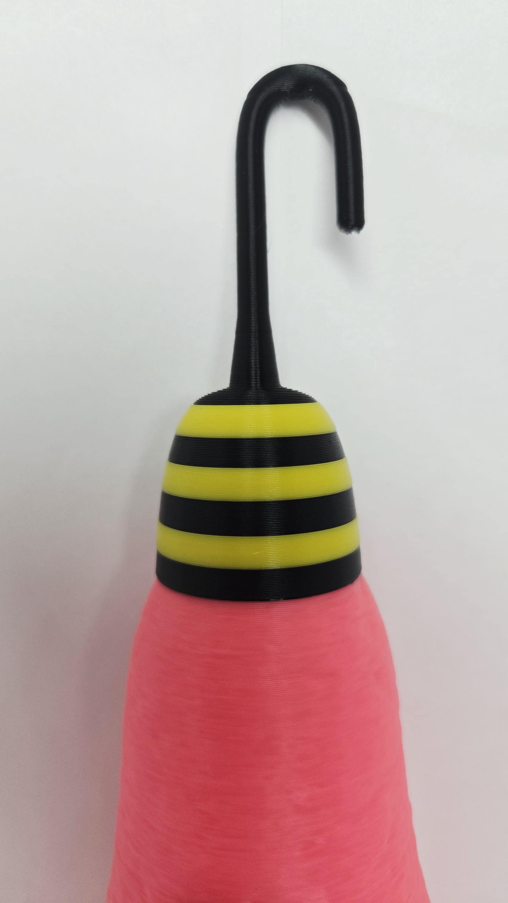 Close-up view of the black-and-yellow striped hook accessory on the cotton candy cocoon prop