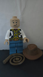 Straight front view of the scaled oversized cowboy sheriff figure with hat and lasso placed beside it