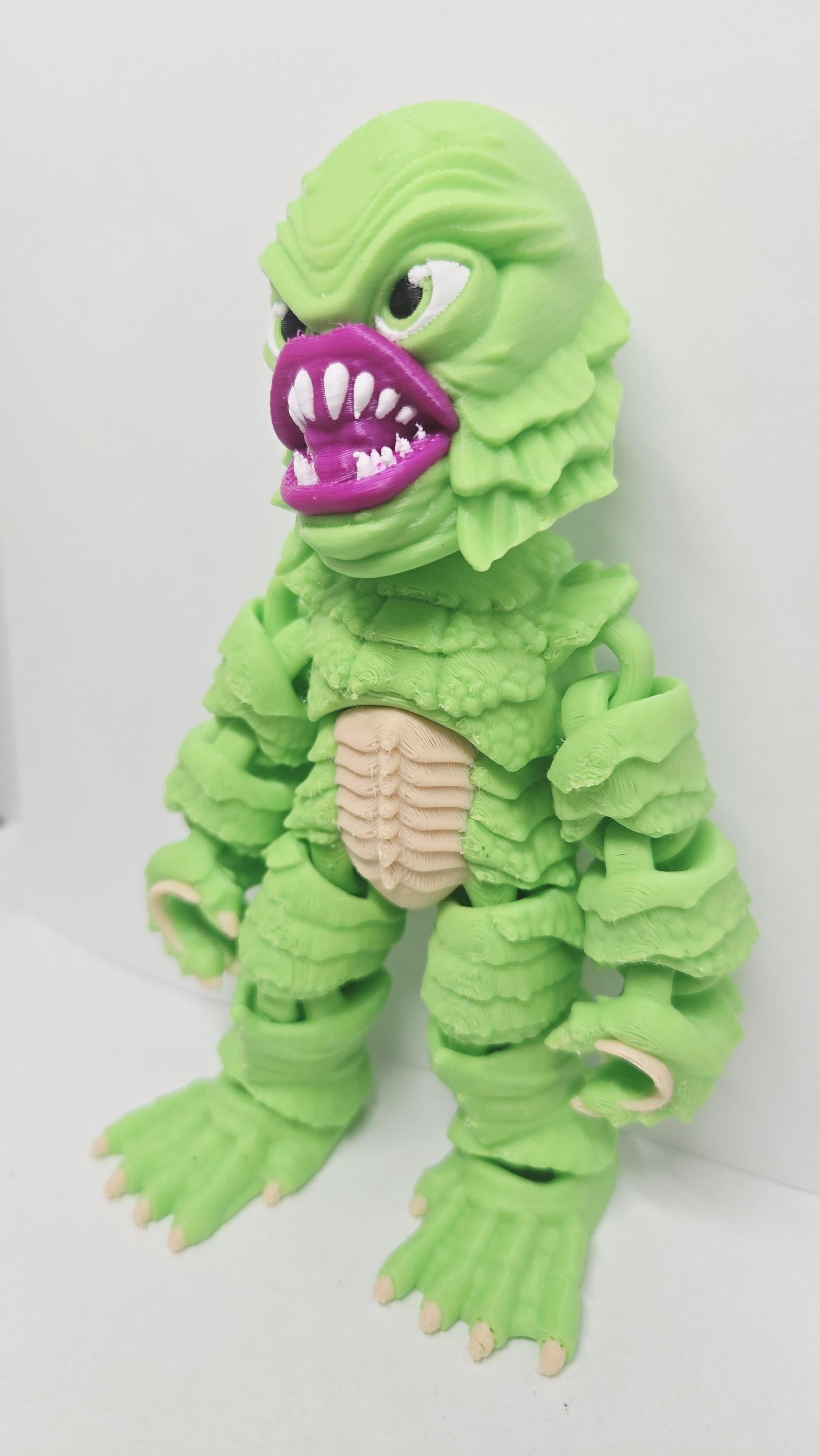 Left side profile view of the flexible Gill-man monster toy showing the distinct side head fins and arm articulation joints