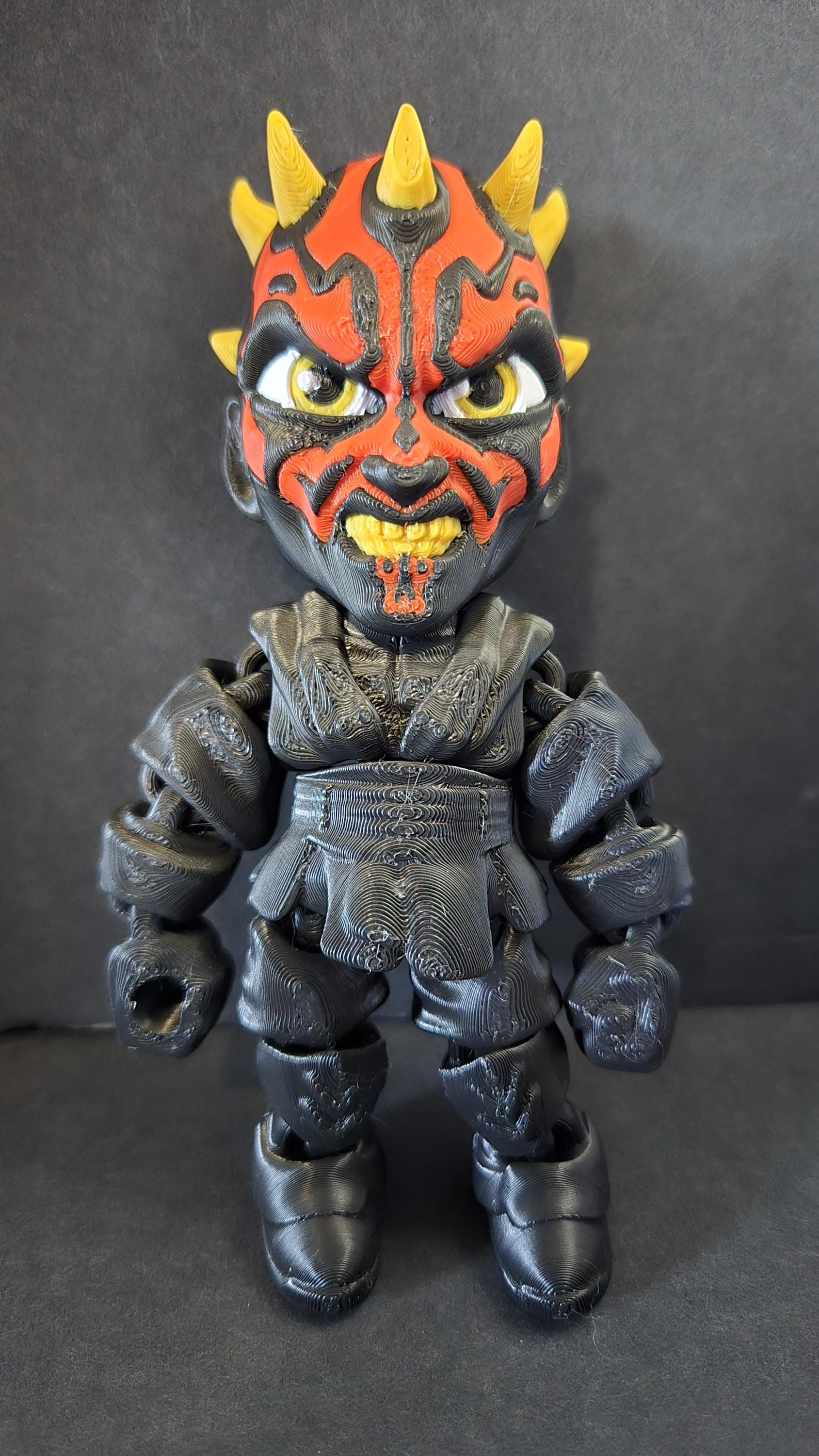 Straight front view focusing on the detailed red and black facial tattoos, crown of horns, and robes of the flexible Darth Maul figure