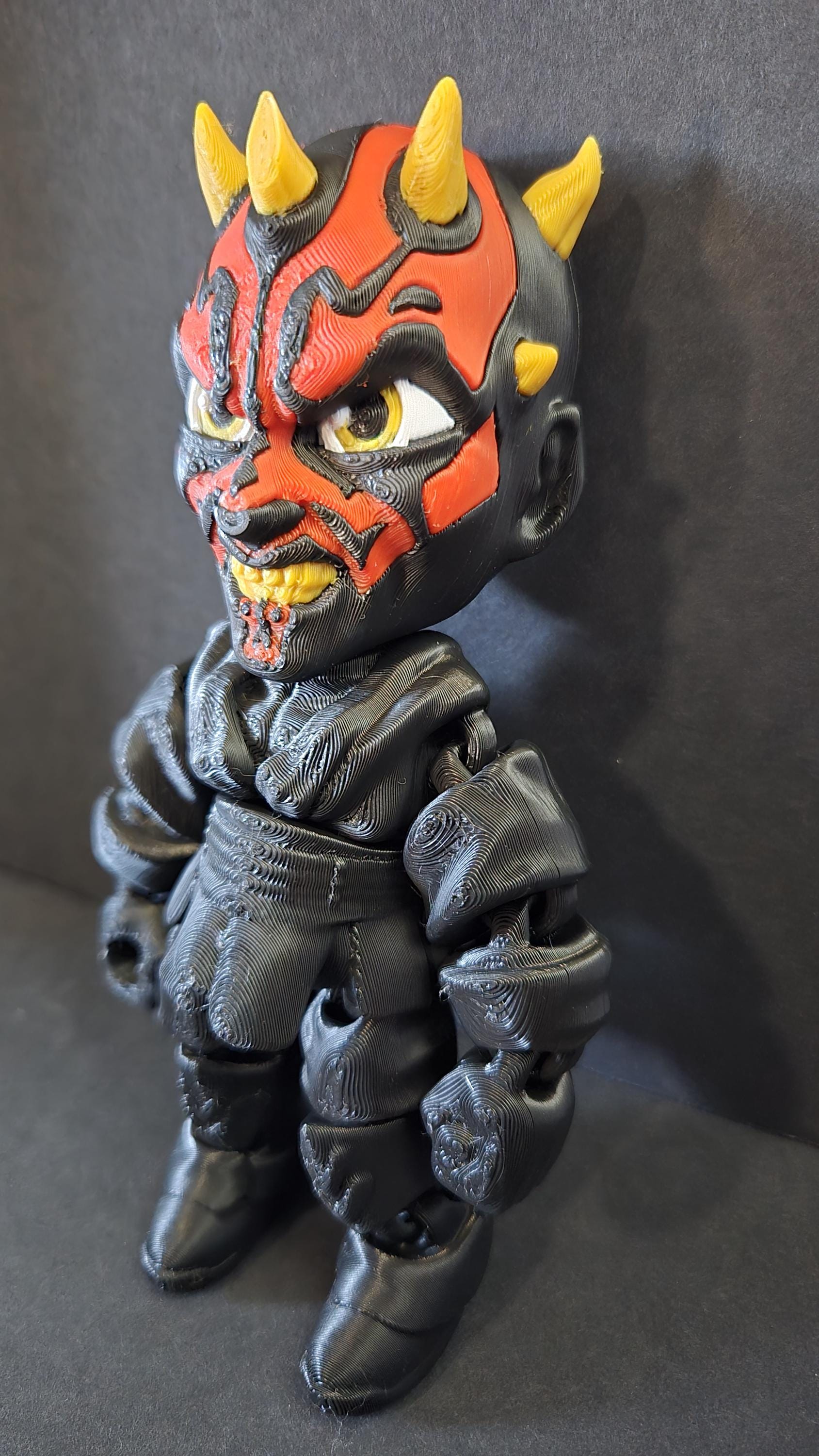 Left side profile view of the flexible Darth Maul toy showing the shoulder robe plates and arm articulation joints