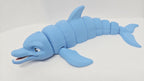 Left side profile view of the flexible dolphin toy showing its streamlined aquatic shape and interconnected joint segments