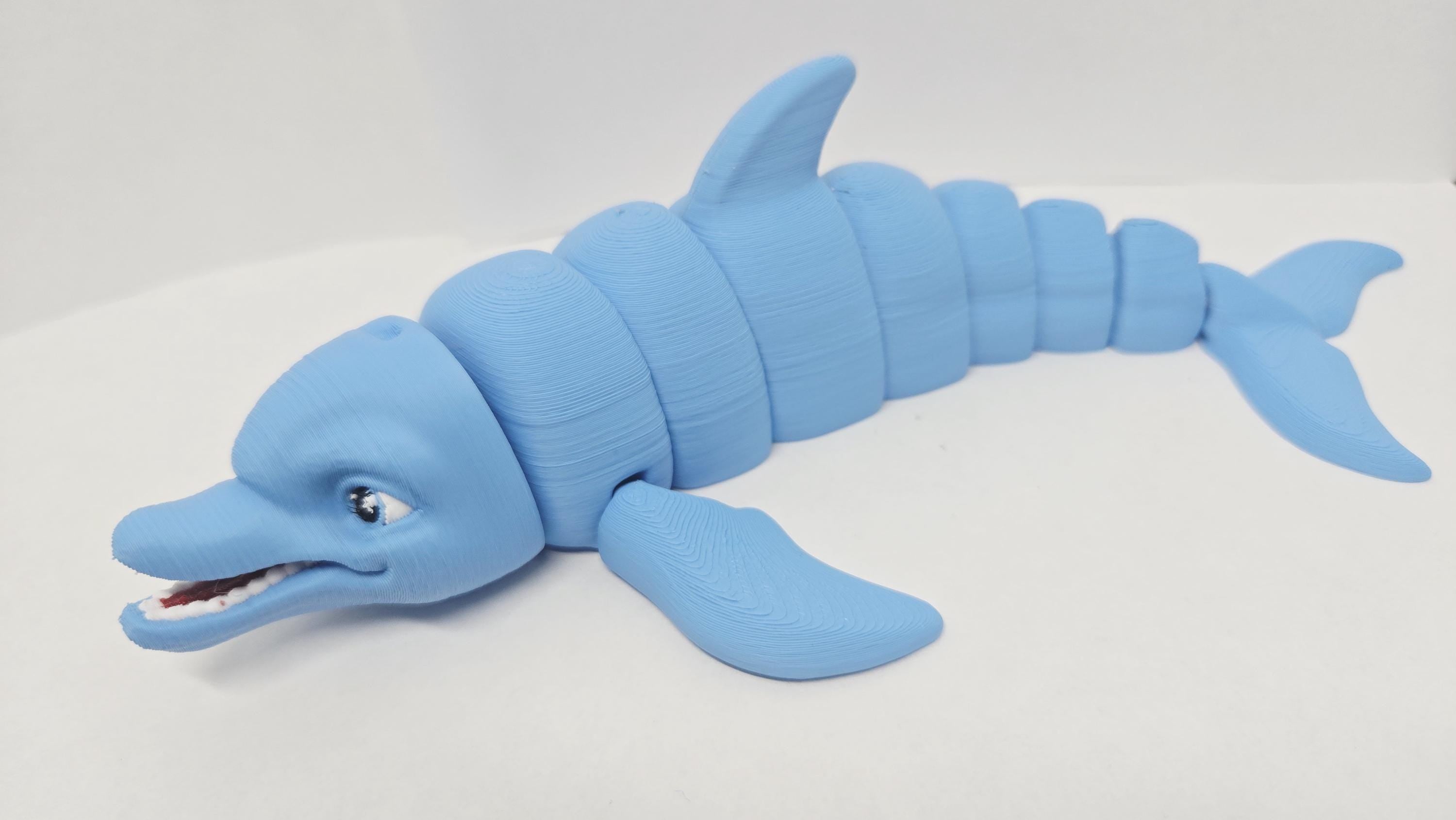 Left side profile view of the flexible dolphin toy showing its streamlined aquatic shape and interconnected joint segments