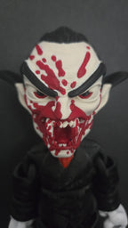 Close-up front view of the Dracula flexi figure showing its detailed fangs and blood-splattered face