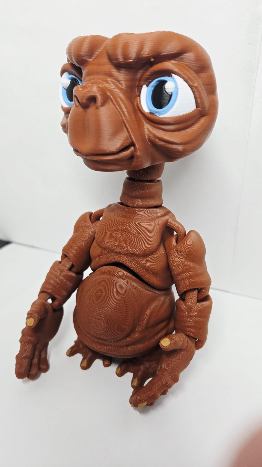 Three-quarter left profile view of the 3D printed E.T. figurine highlighting the clean multi-color print transitions on the face and neck