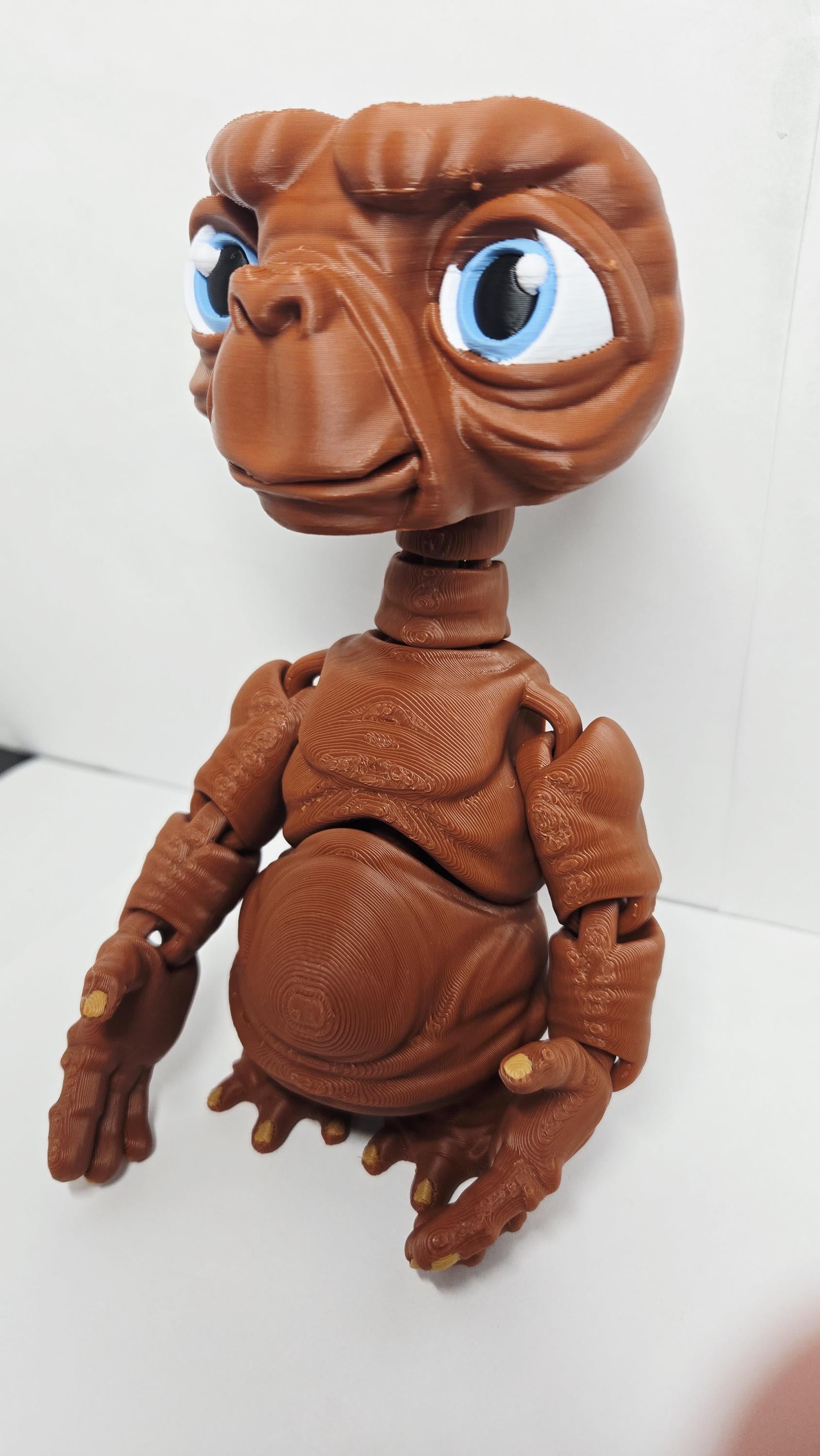 Three-quarter left profile view of the 3D printed E.T. figurine highlighting the clean multi-color print transitions on the face and neck