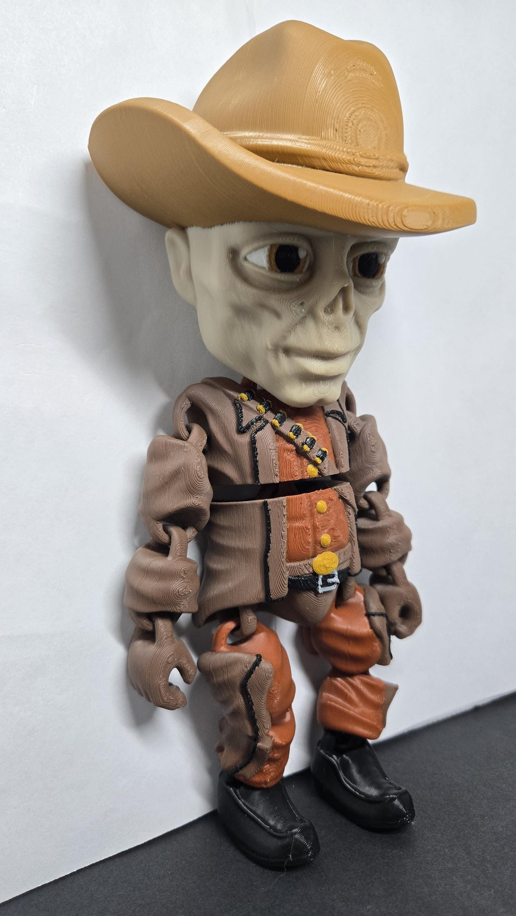 Side profile view of the flexible Ghoul toy showing his gunslinger build, cowboy hat silhouette, and arm articulation joints