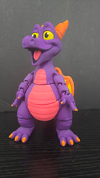 Front view of the Figment flexi figure on a dark studio surface showing its purple body and pink belly