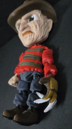 Left side profile of the 3D printed Freddy Krueger figure showing the arm joint placement and side of the hat