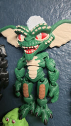 Left side profile view of the flexible Stripe monster toy showing the long ears, textured side profile, and arm articulation joints