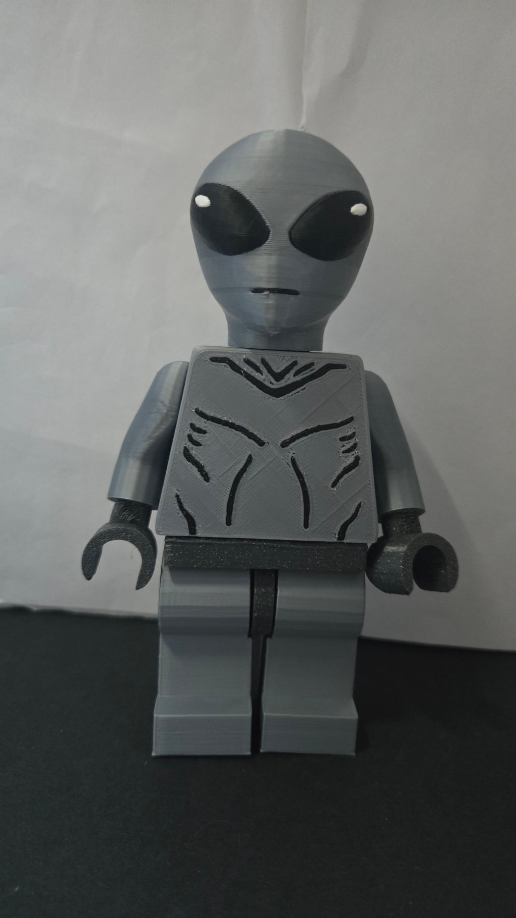 Straight front view of the scaled oversized Grey Alien figure showcasing the jumpsuit detail