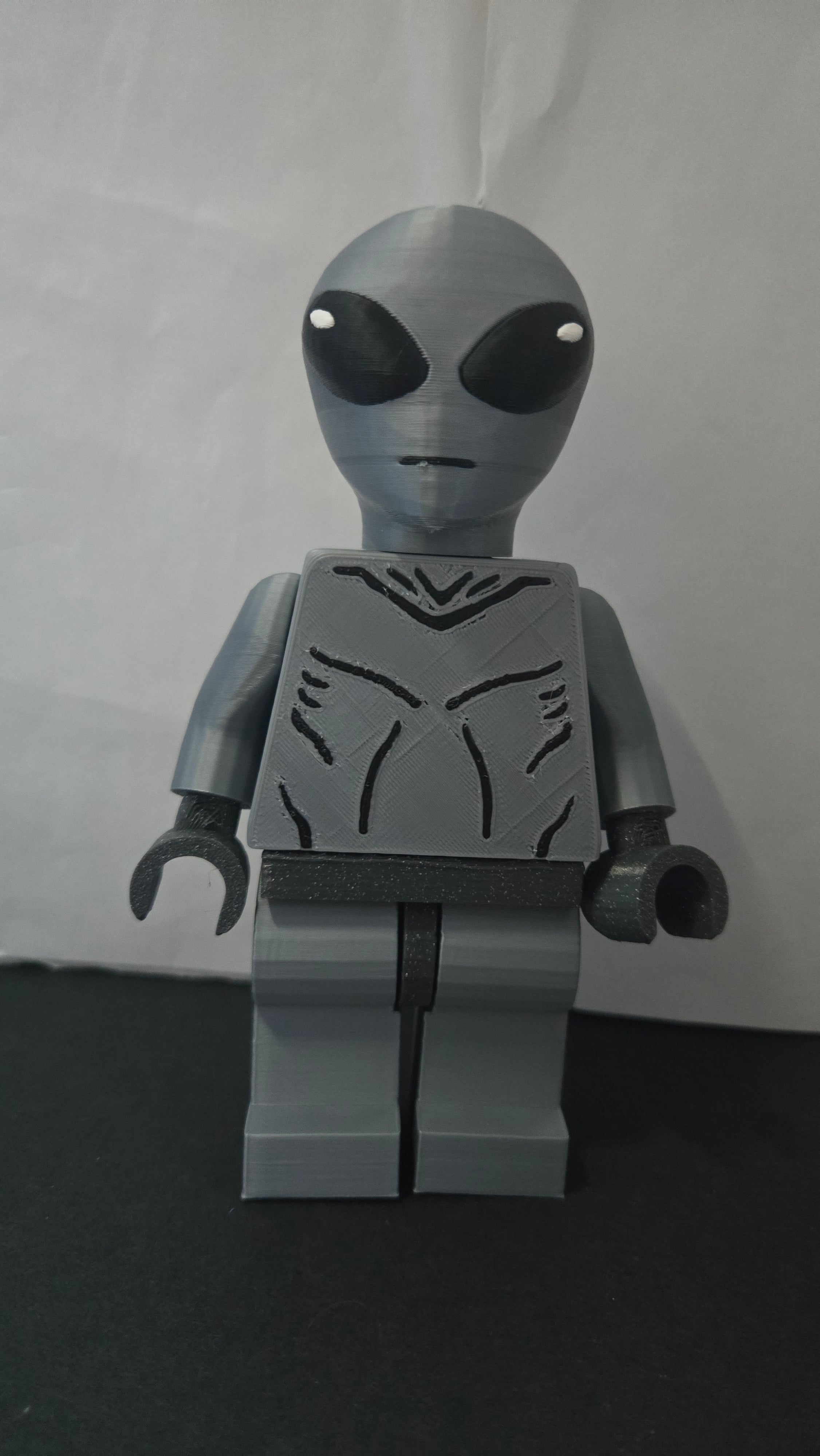 Straight front view of the scaled oversized Grey Alien figure showcasing the jumpsuit detail
