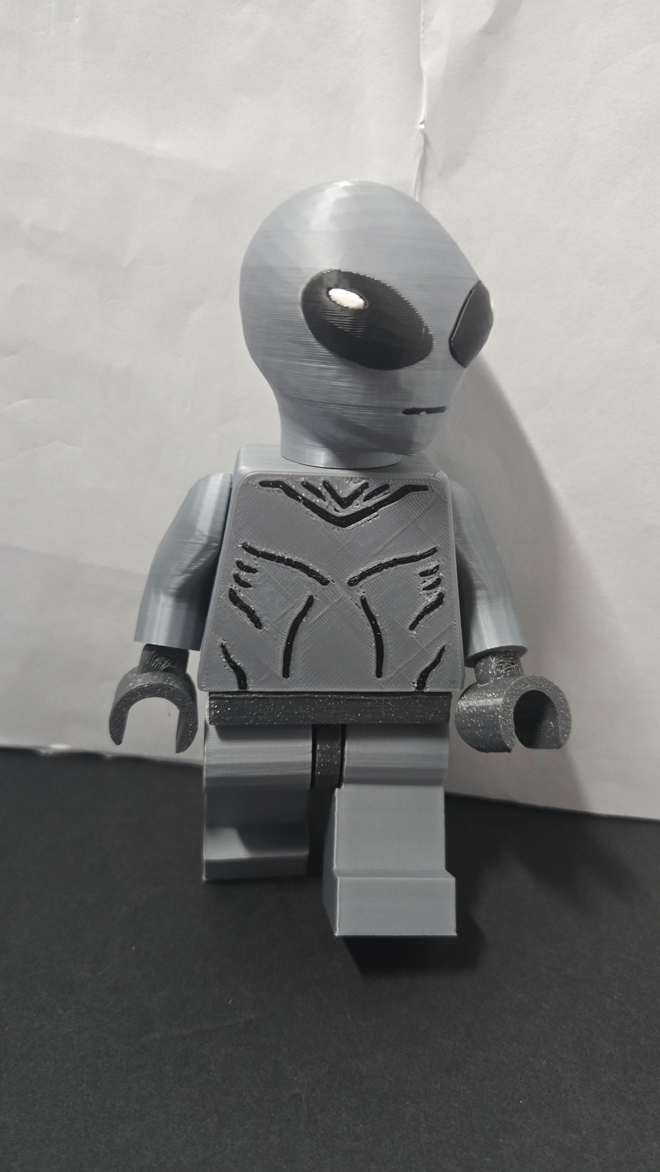 Three-quarter view of the oversized Grey Alien brick megafig showing its stride and head shape