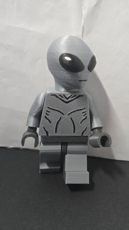 Three-quarter view of the oversized Grey Alien brick megafig showing its stride and head shape