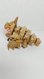 Left side profile view of the flexible Gronckle toy showing its stout body shape, clubbed tail, and limb articulation joints