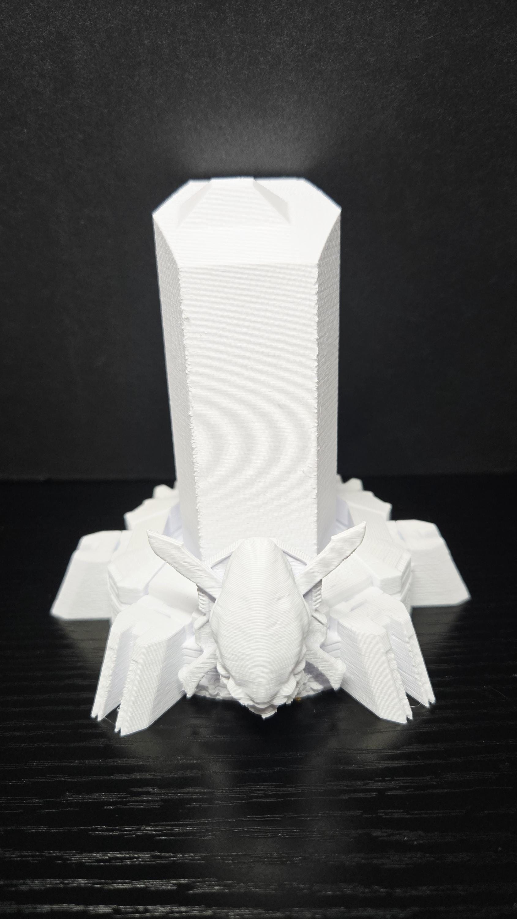 Front-facing close-up of the unpainted 3D printed futuristic display pedestal base showing the clean geometric design
