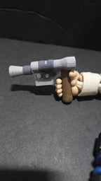Macro close-up shot of the 3D printed Han Solo figure's hand securely holding the detailed silver and brown DL-44 heavy blaster pistol