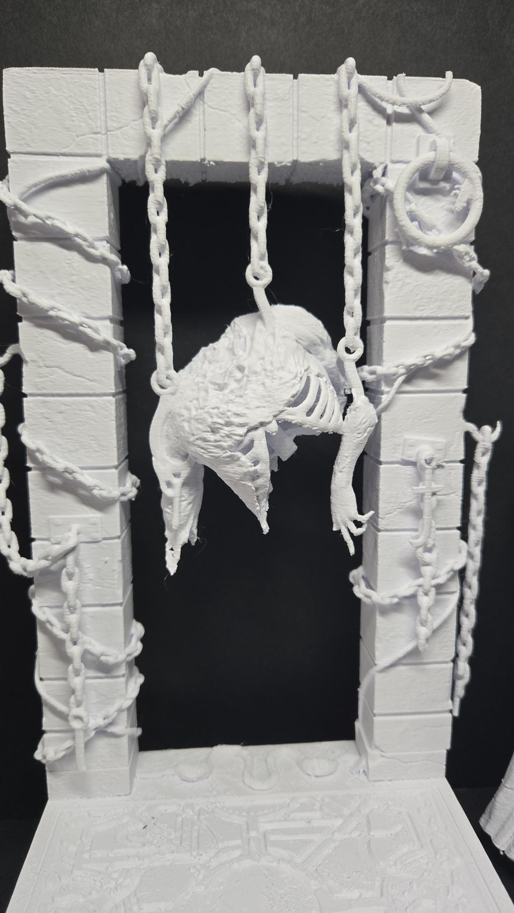 Close-up view of the architectural background and chain detailing on the diorama