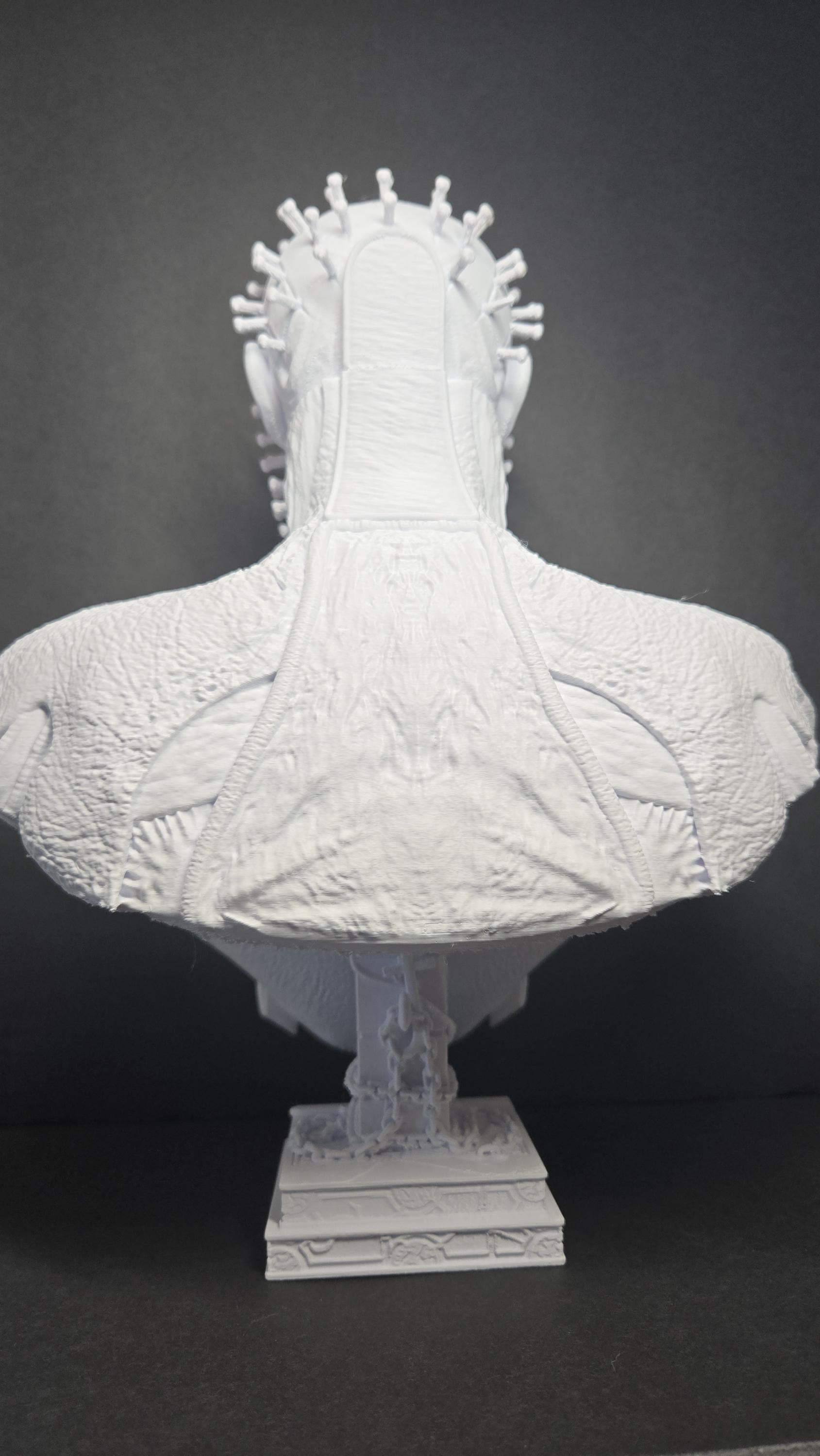 Rear view of the unpainted Pinhead Cenobite statue showcasing the back of the head grids, neck muscles, and high-collared robes