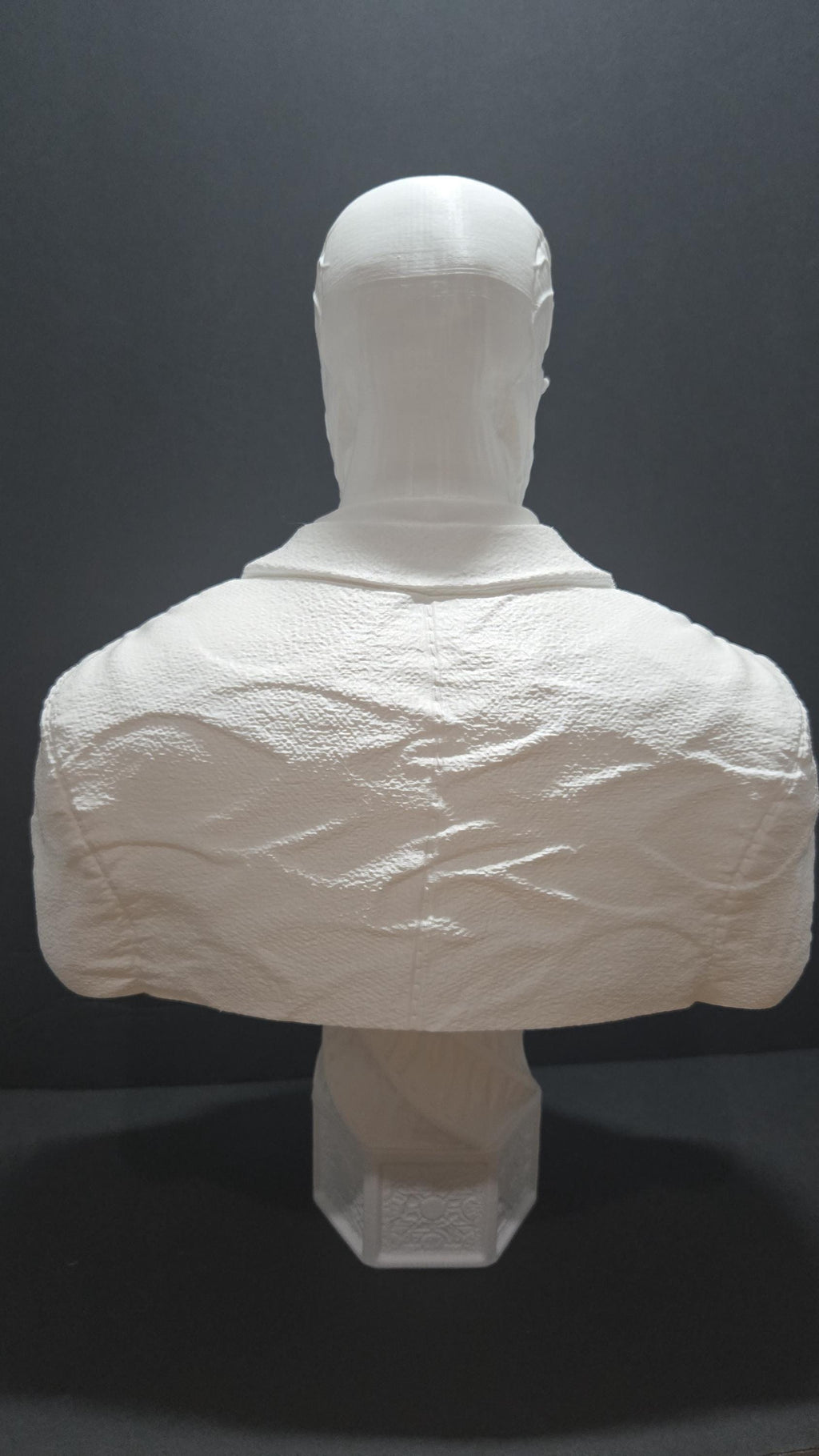 Rear view of the unpainted 3D printed Frank Cotton statue focusing on the smooth head sculpture and the back of the textured suit coat
