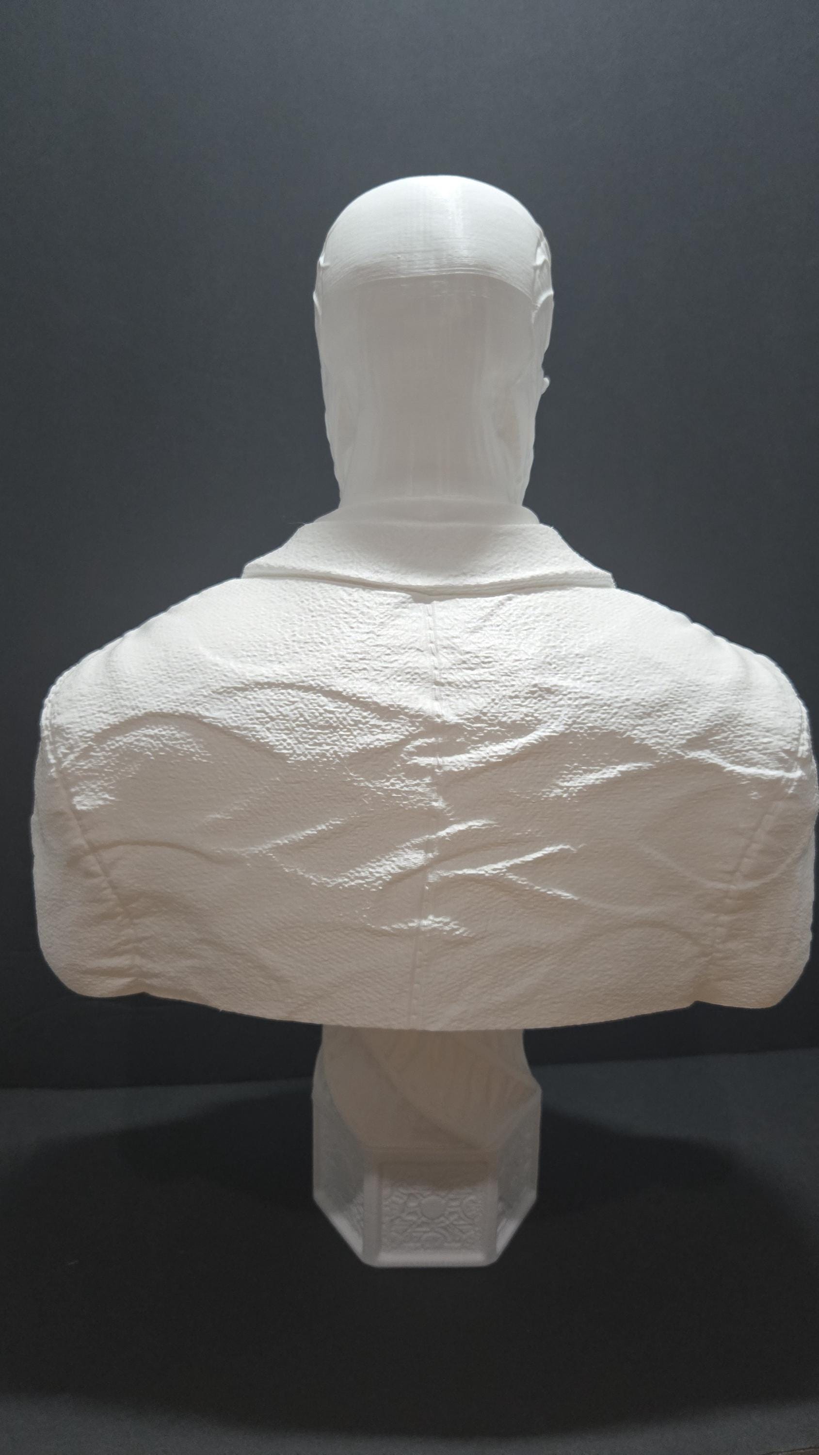 Rear view of the unpainted 3D printed Frank Cotton statue focusing on the smooth head sculpture and the back of the textured suit coat
