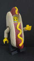 Oversized Hot Dog Guy brick megafig standing in full costume against a dark studio background