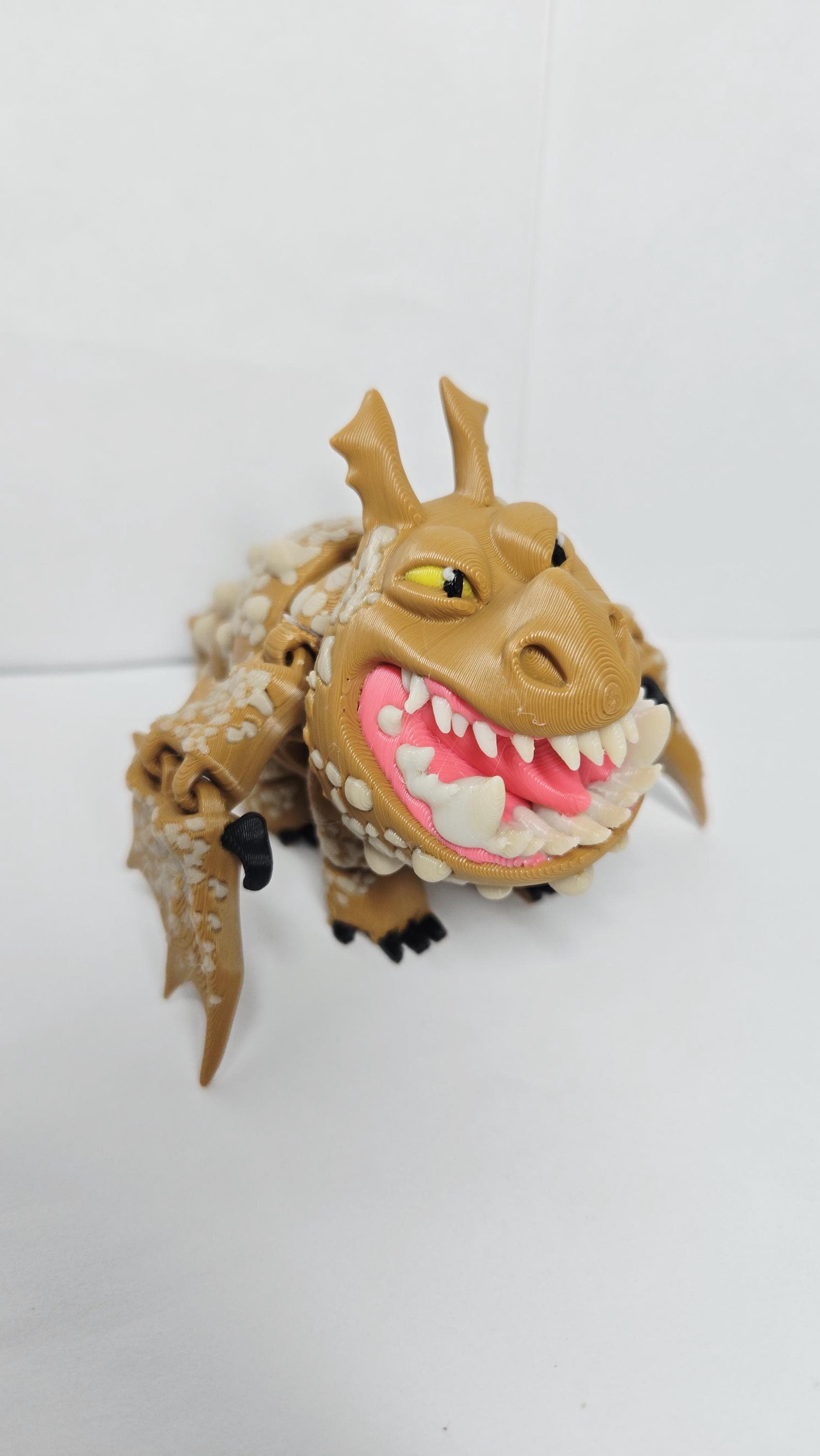 Full-color 3D printed How to Train Your Dragon Gronckle flexi figure standing upright on a flat surface as the main product view