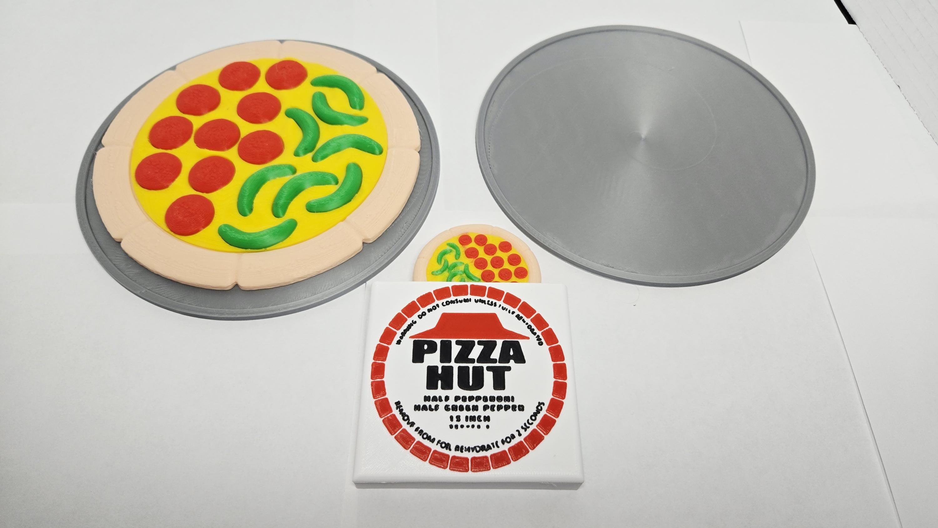 Hydrator prop display showing the fully expanded pepperoni and pepper pizza next to the dehydrated disk