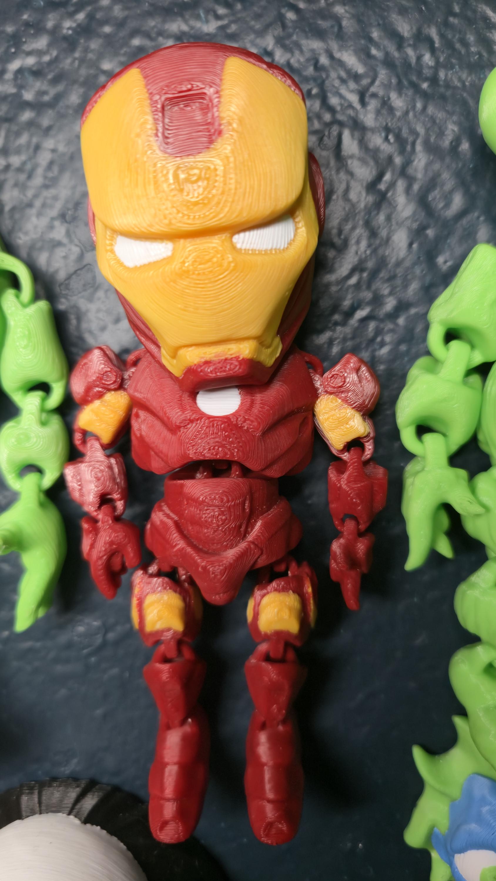 Straight front view focusing on the detailed red and gold helmet, face plate, and chest arc reactor of the flexible Iron Man figure