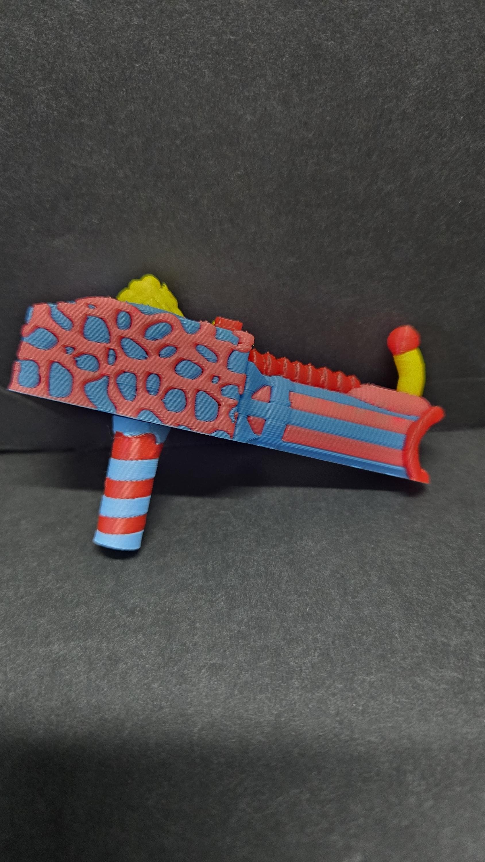 Side view of the detached, colorful 3D printed popcorn gun accessory