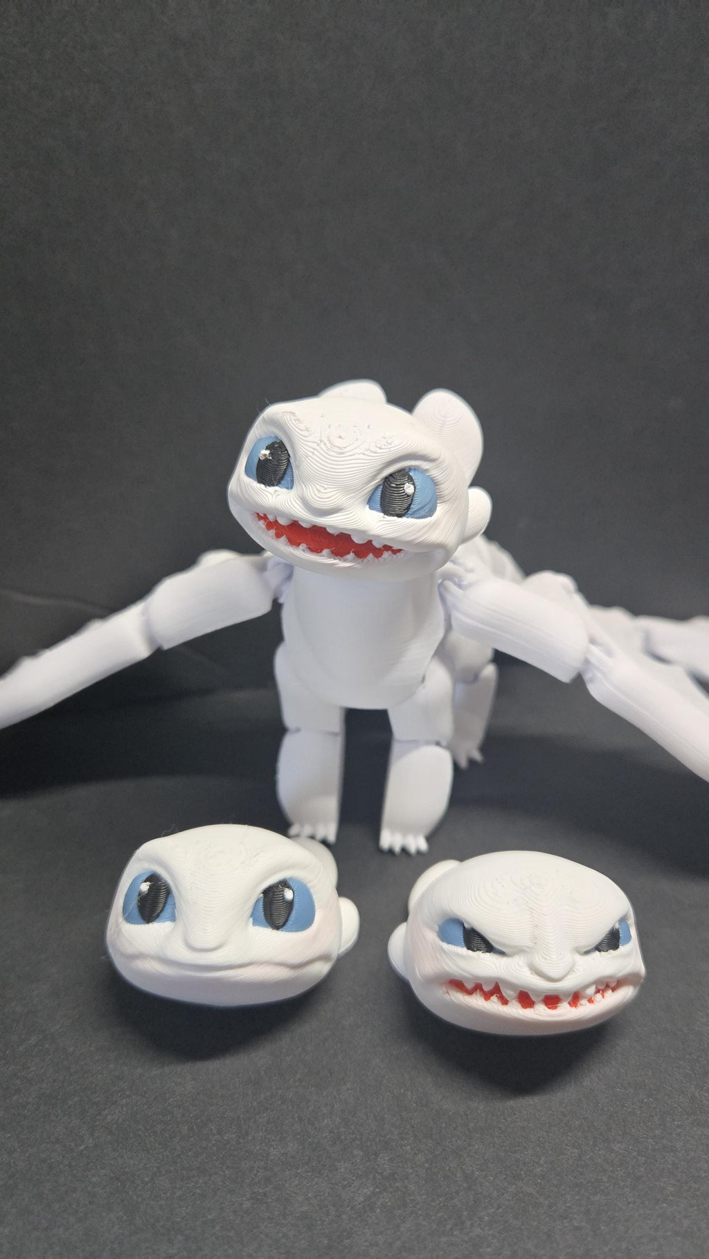 Light Fury articulated dragon figure shown alongside all three swappable head expressions