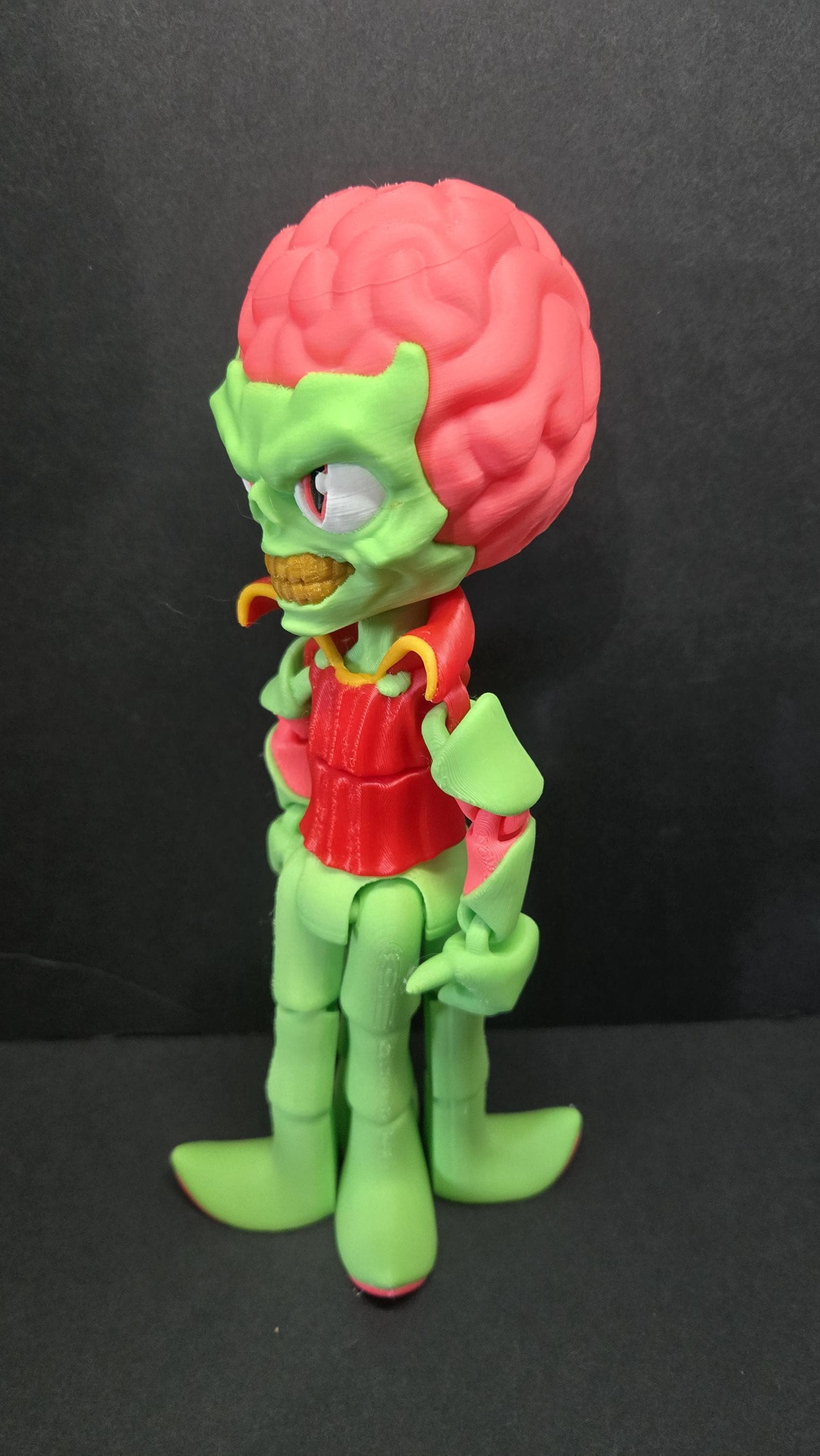 Left side profile view of the flexible Mars Attacks alien toy showing the head curvature and arm articulation joints