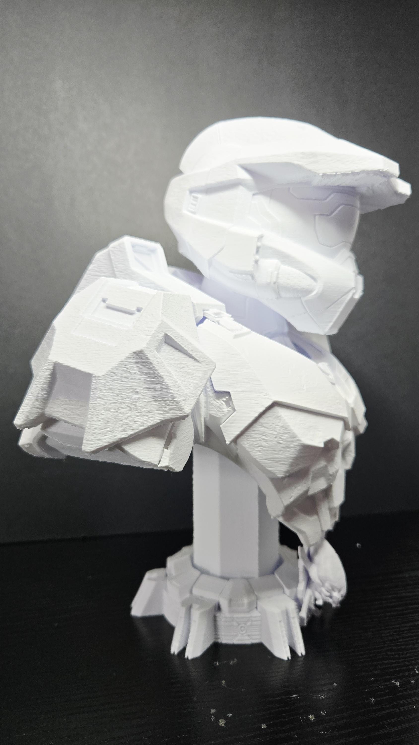 Three-quarter right side view of the unpainted Master Chief bust showcasing the angular helmet visor and shoulder armor plates