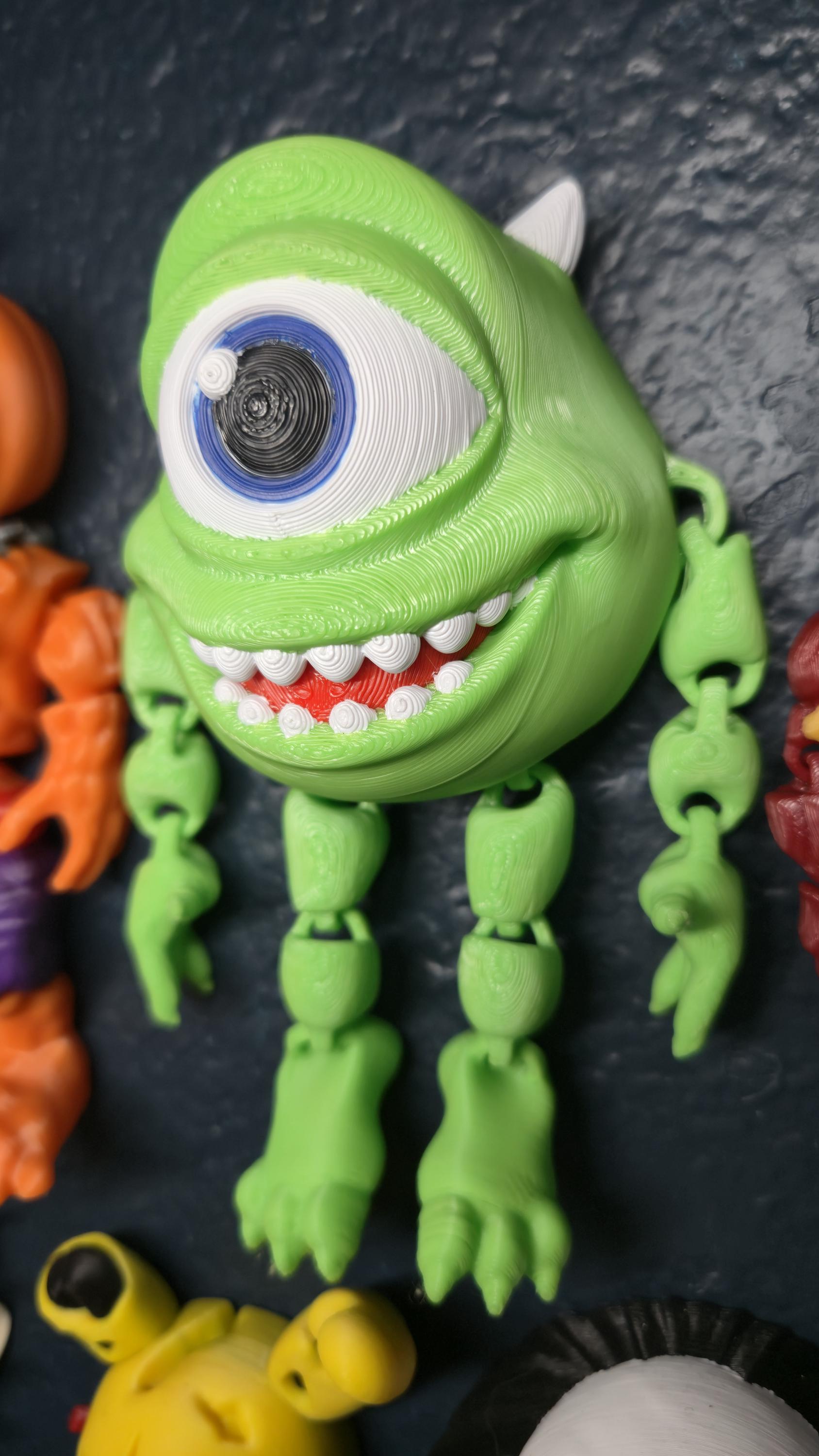 Left side profile view of the flexible Mike Wazowski toy showing the smooth skin texture and thin arm articulation joints