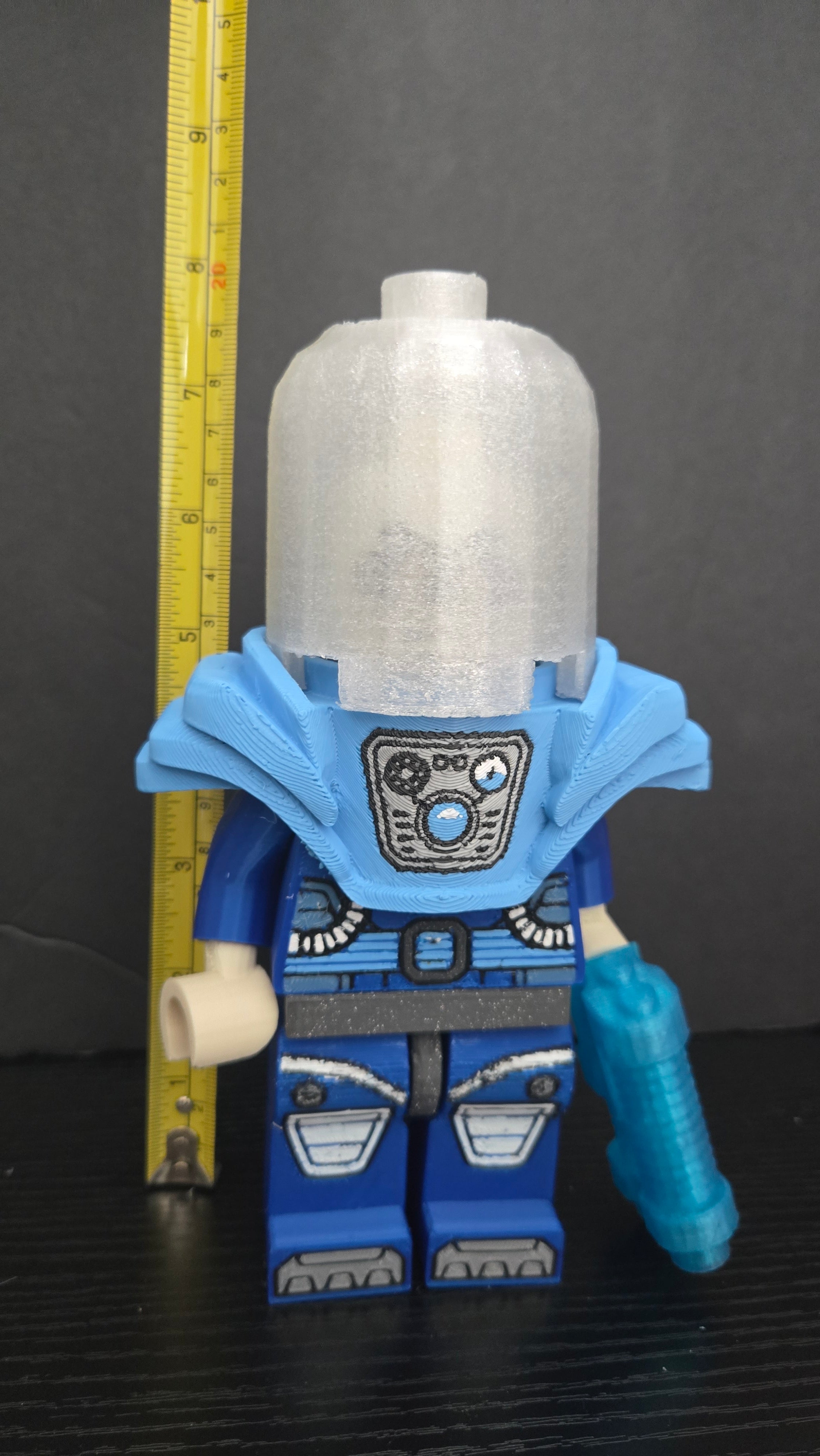 Mr. Freeze brick megafig standing next to a yellow measuring tape to display its height scale