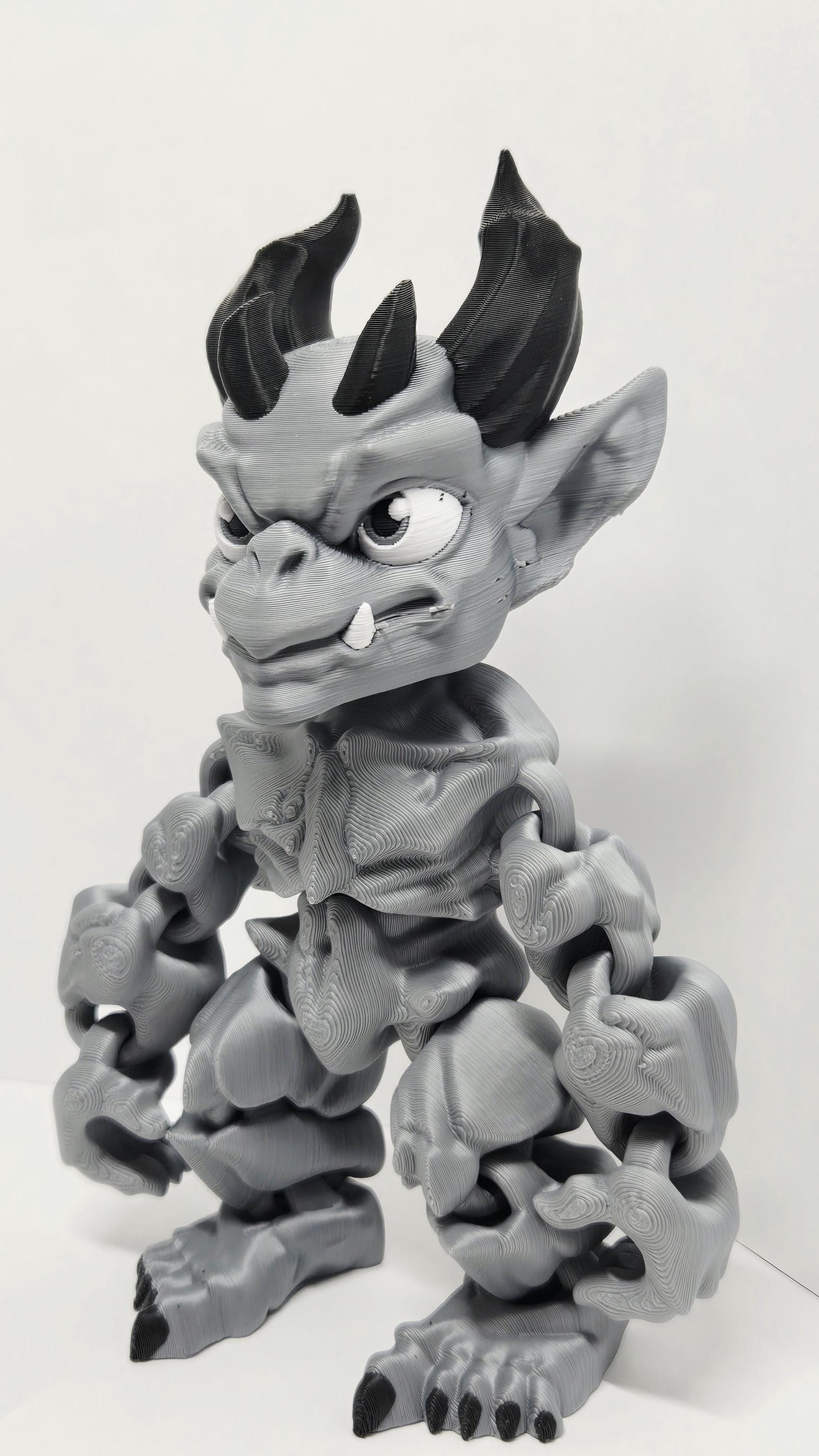 Left side profile view of the flexible gargoyle monster toy showing the wing curvature and arm articulation joints