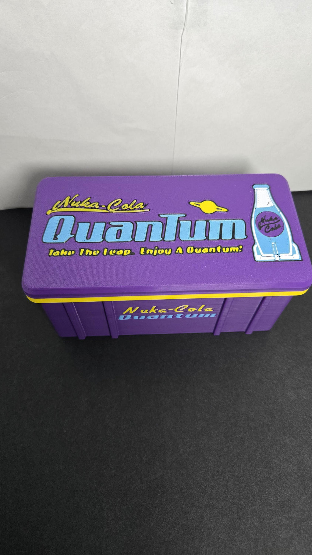 Top-down view of the storage box lid focusing on the Nuka-Cola Quantum logo and branded graphics