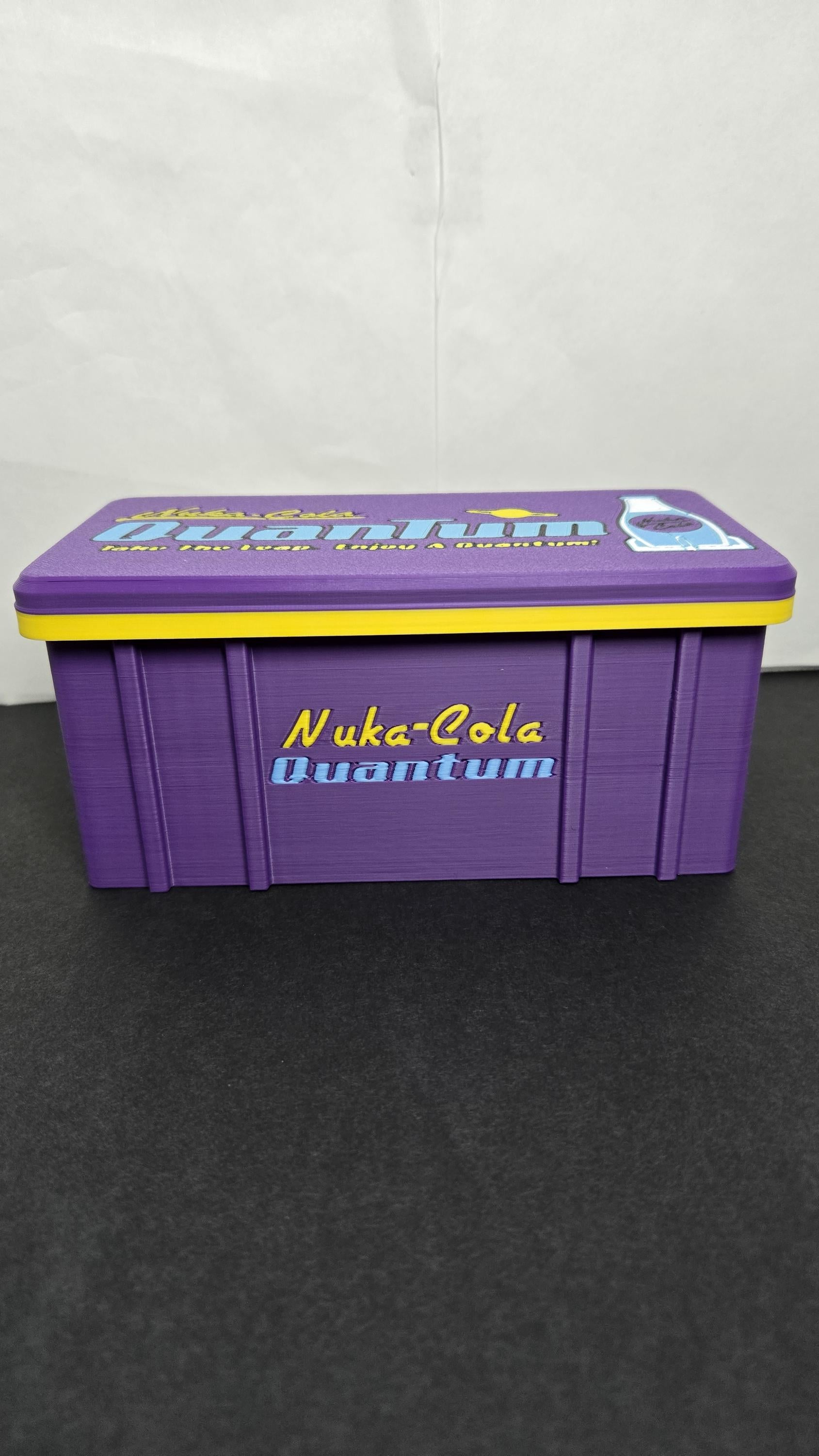 Front view of the closed Nuka-Cola Quantum stash box showcasing the vibrant branding and purple color scheme
