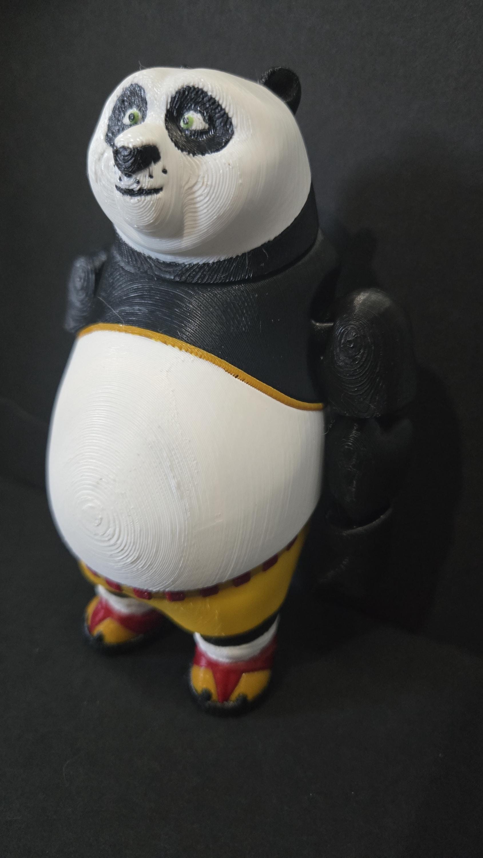 Left side profile view of the flexible Po toy showing the round stance profile and arm articulation joints