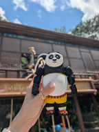 Straight front view focusing on the detailed panda face, bright eyes, and martial arts shorts of the flexible Po figure