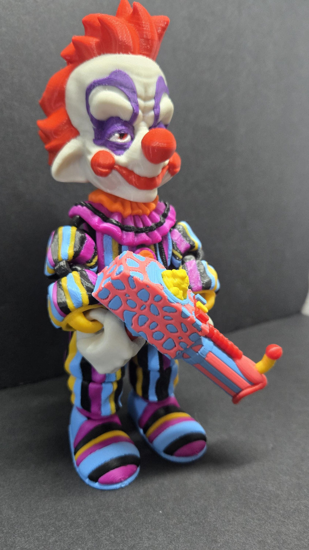 Three-quarter view of the Rudy flexi figure posing with his popcorn gun accessory