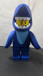 Straight front view of the scaled oversized Shark Suit brick figure showing the shark headpiece