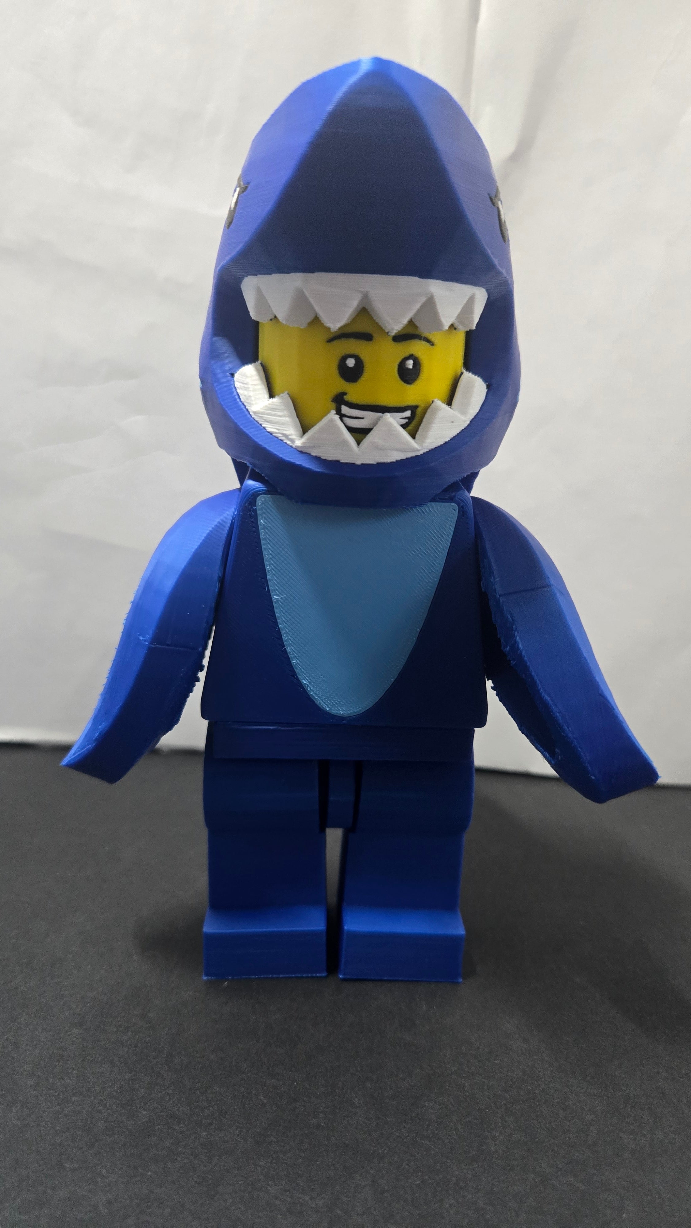 Straight front view of the scaled oversized Shark Suit brick figure showing the shark headpiece