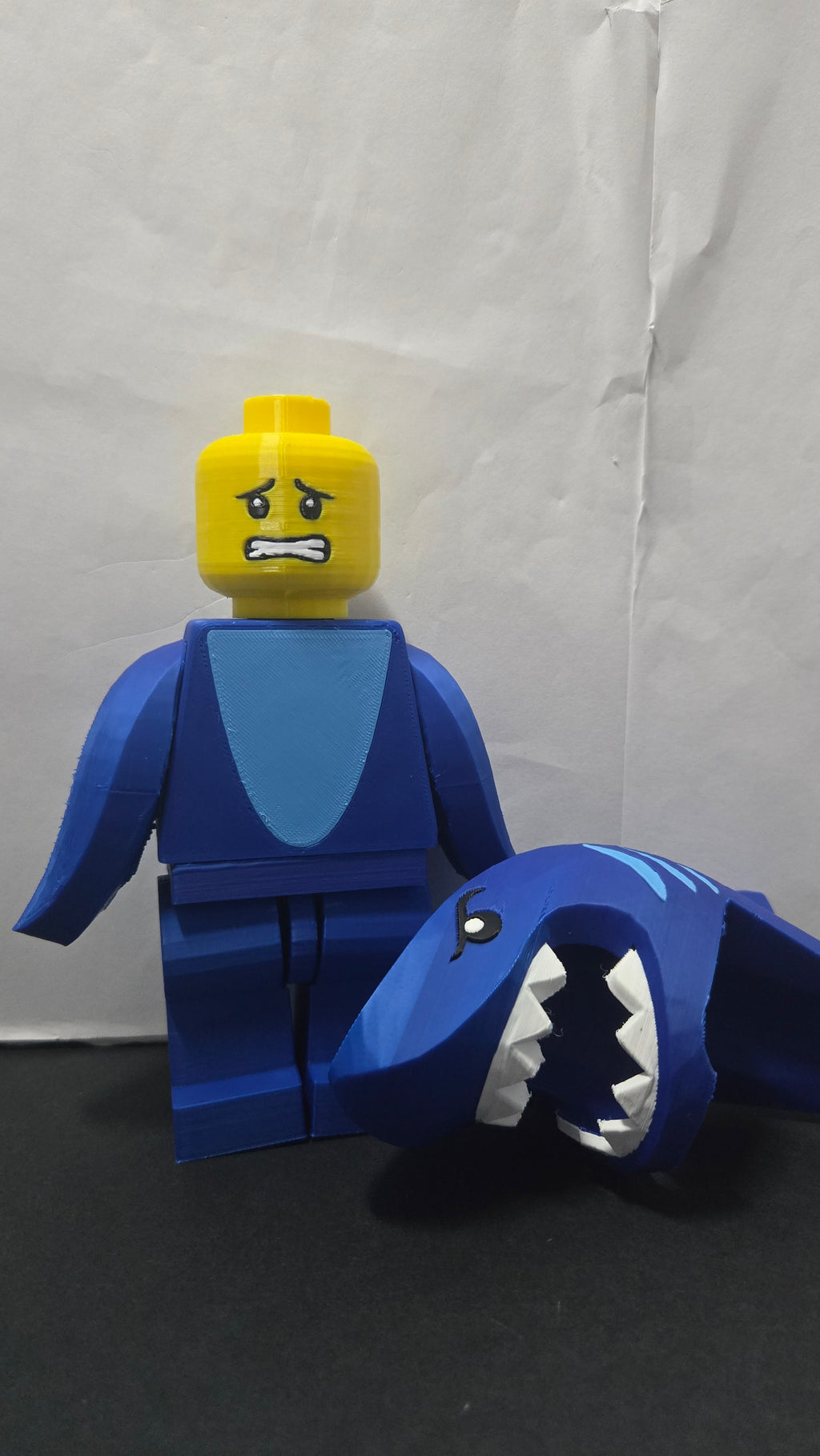 Shark Suit megafig displaying an alternative facial expression with the shark hood placed beside the figure