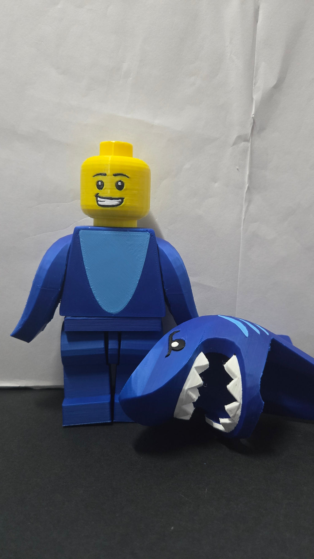 Shark Suit megafig shown with the shark hood removed next to the body to reveal the minifigure face
