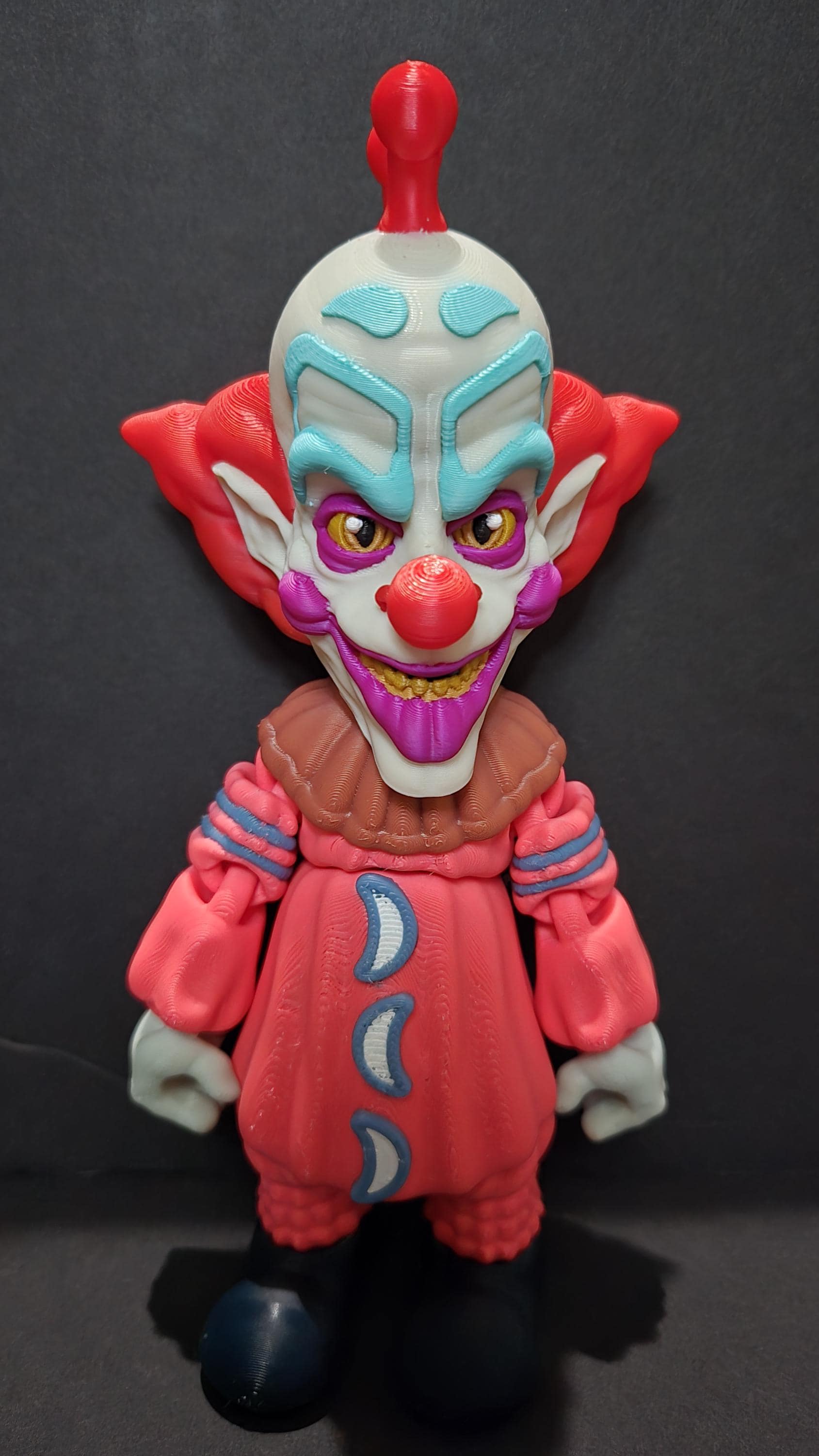 Straight front view of the 3D printed Slim flexi figure showing his hair and patterned clown suit